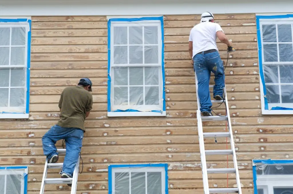 two men working on house siding with ladders 2026 03 26 07 24 21